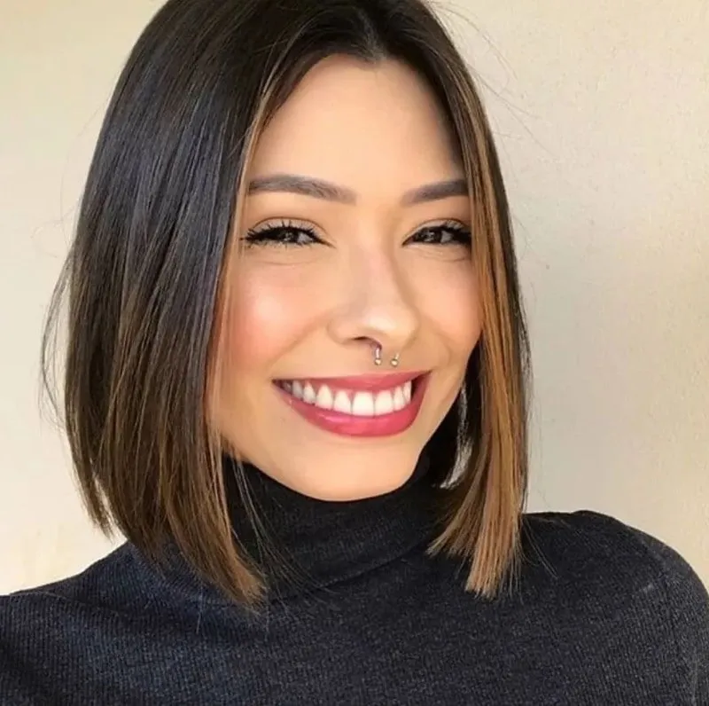 Mujer sonriente con lob recto a la altura del hombro, cabello lacio oscuro con mechas caramelo