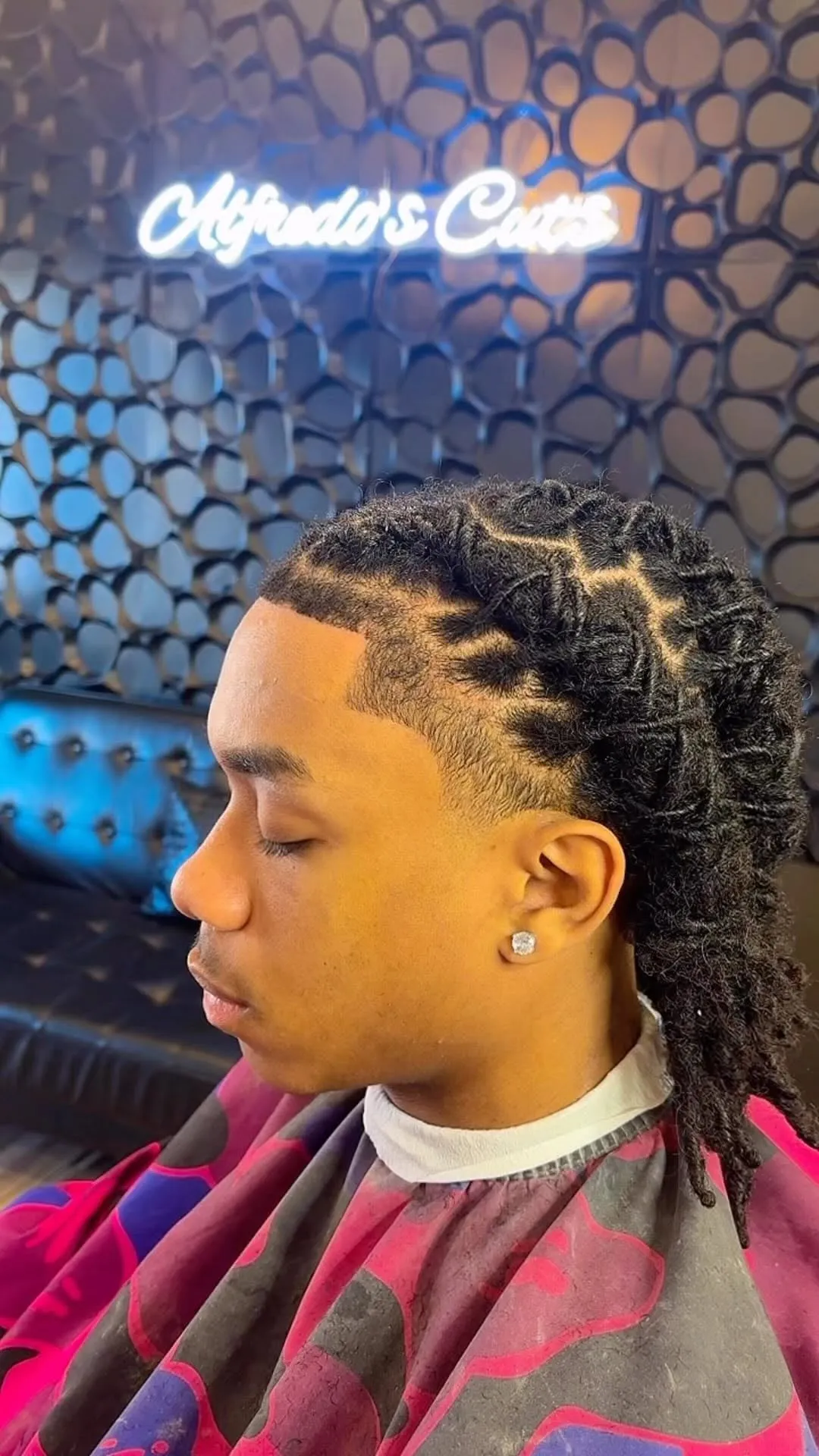 Taper fade bajo con twists en la parte de arriba en cabello afro, visto de lado